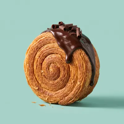 Choco Bliss Roll — New York Roll mit Schokoladenglasur und Schokoraspeln, auf der Kante stehend